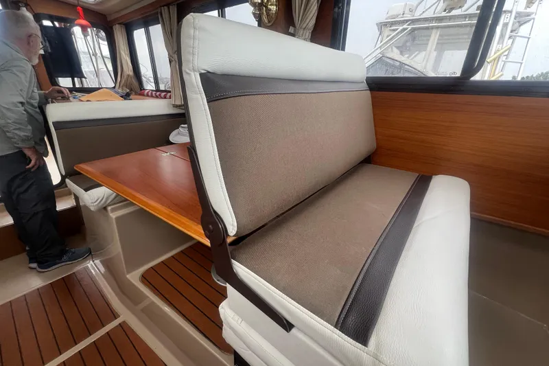 Slide: The Image of Interior of 2017 Ranger Tugs R-27 Tug with seating and wooden table. - 14