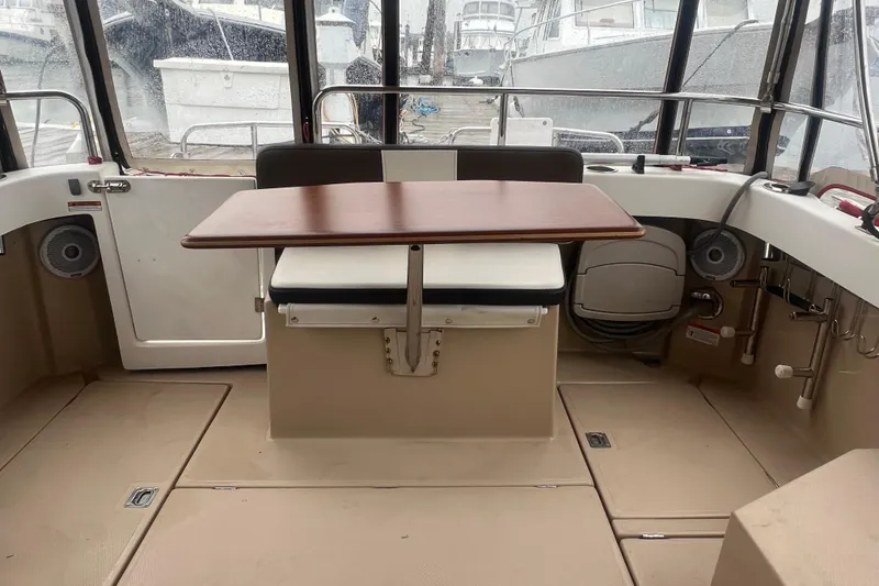 Slide: The Image of 2017 Ranger Tugs R-27 Tug interior with table and seating, docked at marina. - 18