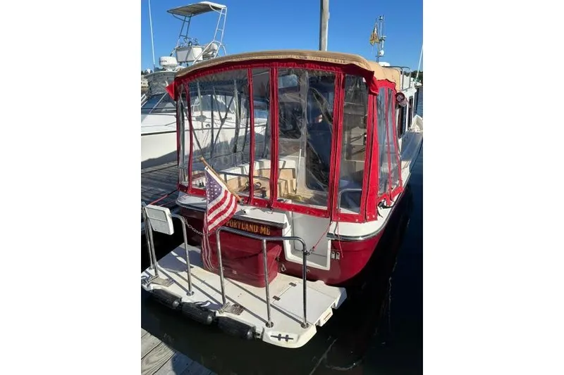 Slide: The Image of 2017 Ranger Tugs R-27 Tugboat with red canopy, docked with American flag. - 27