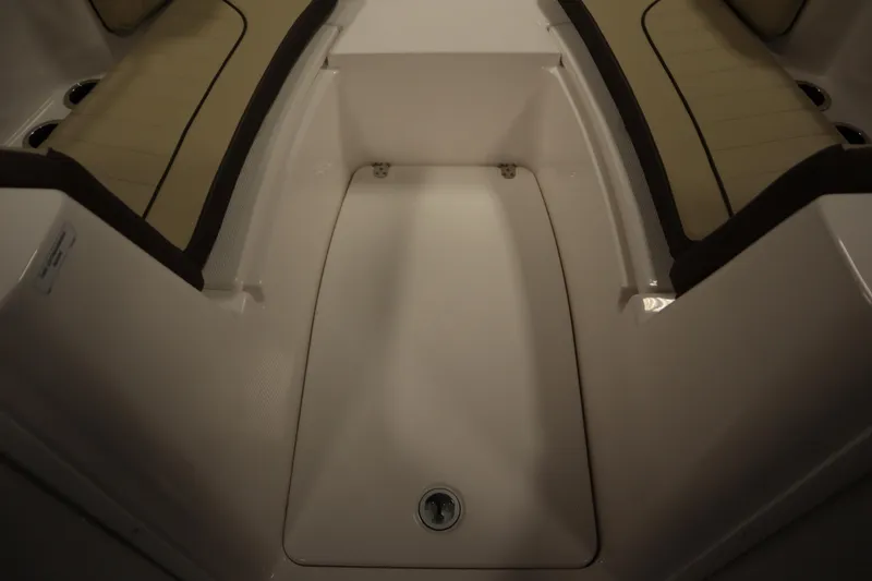 Slide: The Image of Interior seating of 2026 Yamaha Boats 222 FSH Sport, featuring beige cushions and storage area. - 15