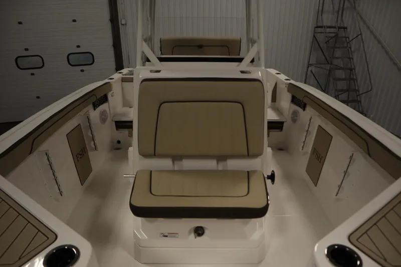 Slide: The Image of 2026 Yamaha Boats 222 FSH Sport interior with beige seating in a garage setting. - 17