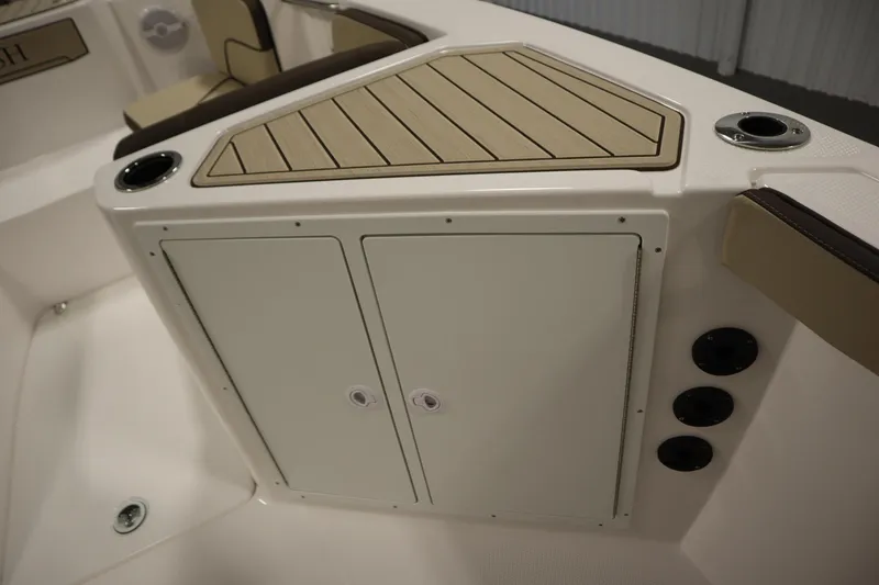 Slide: The Image of 2026 Yamaha Boats 222 FSH Sport interior storage compartment with cup holders and seating. - 18