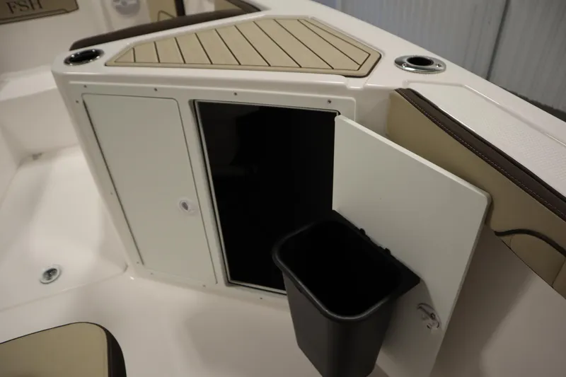 Slide: The Image of 2026 Yamaha Boats 222 FSH Sport interior storage compartment with open door and trash bin. - 19
