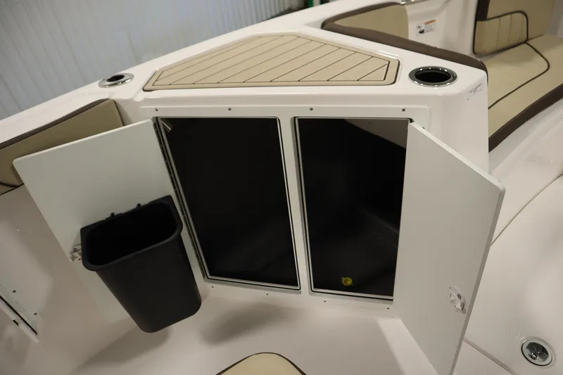 Slide: The Image of 2026 Yamaha Boats 222 FSH Sport storage compartment with open doors and trash bin. - 21