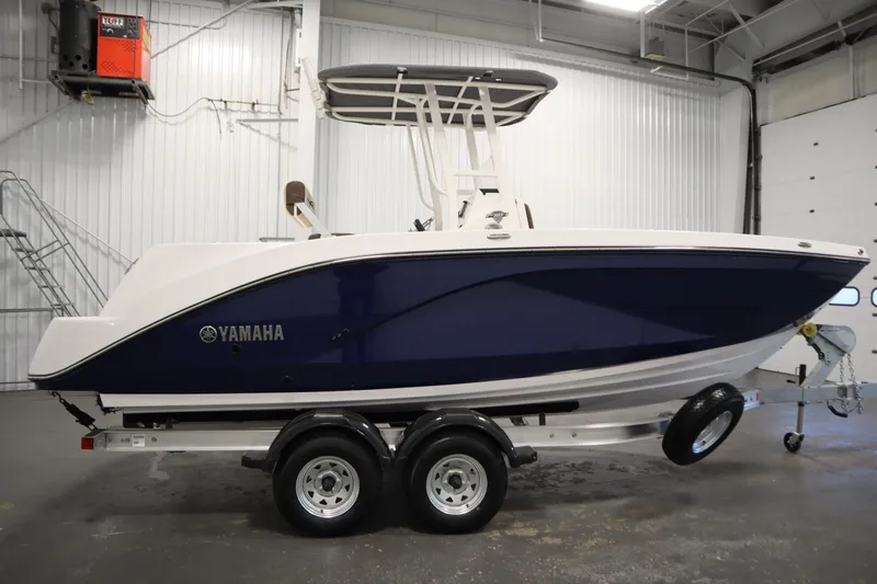Slide: The Image of 2026 Yamaha Boats 222 FSH Sport in a showroom, side view on trailer. - 3