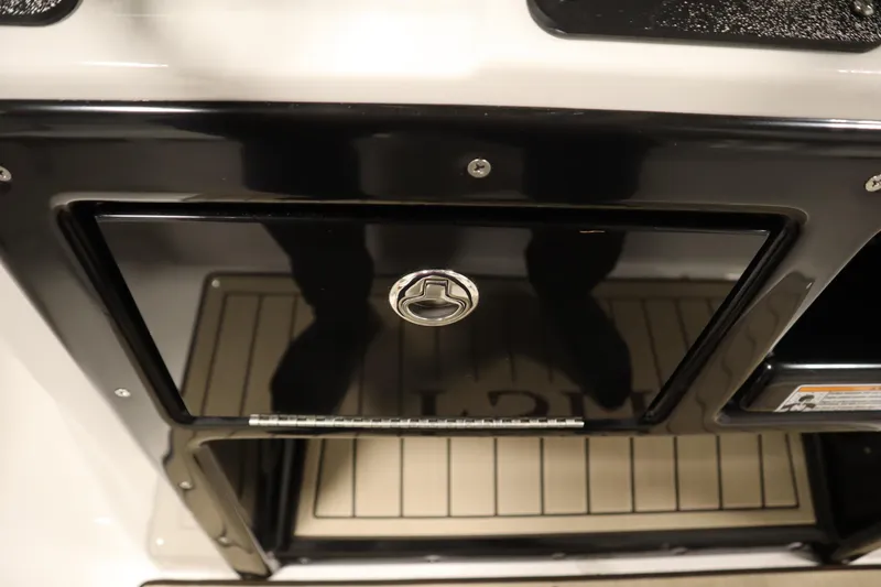 Slide: The Image of 2026 Yamaha Boats 222 FSH Sport storage compartment with sleek black finish and secure latch. - 34