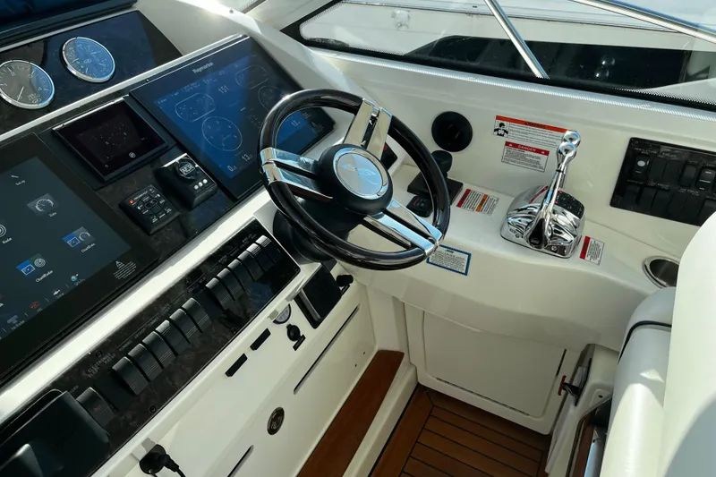 Slide: The Image of Cockpit of 2010 Sea Ray 450 Sundancer with modern controls and steering wheel. - 14