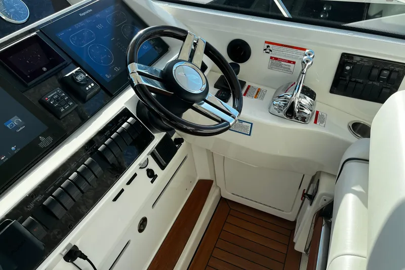 Slide: The Image of Cockpit of 2010 Sea Ray 450 Sundancer with modern controls and steering wheel. - 15