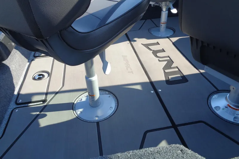 Slide: The Image of 2026 Lund 1875 Impact XS Sport boat interior with seating and branded flooring. - 13