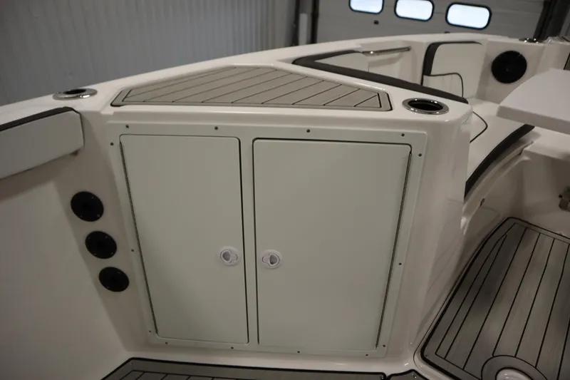Slide: The Image of 2026 Yamaha Boats 222 FSH Sport E interior with storage compartments and cup holders. - 19