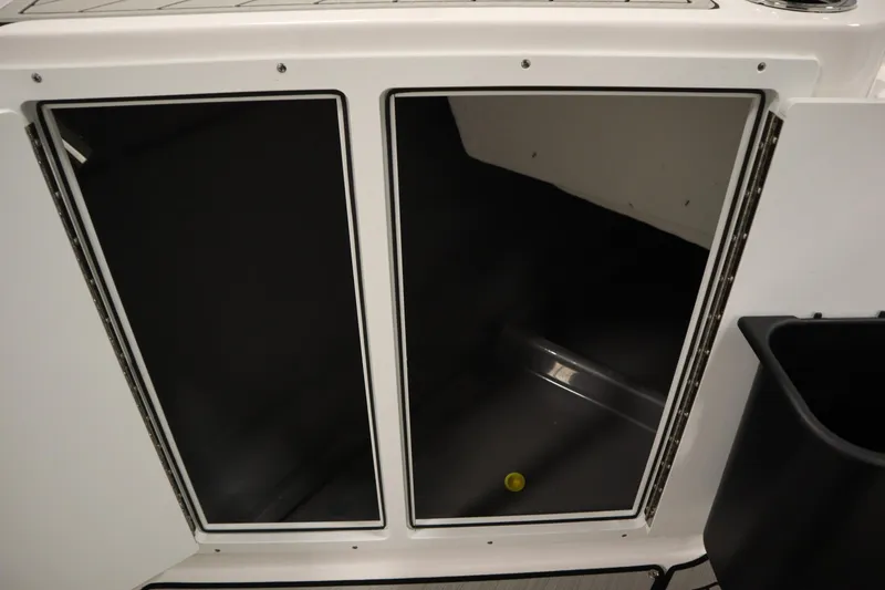 Slide: The Image of Storage compartment of 2026 Yamaha Boats 222 FSH Sport E, featuring dual doors. - 20