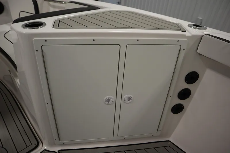 Slide: The Image of 2026 Yamaha Boats 222 FSH Sport E storage compartment with cup holders and sleek design. - 22