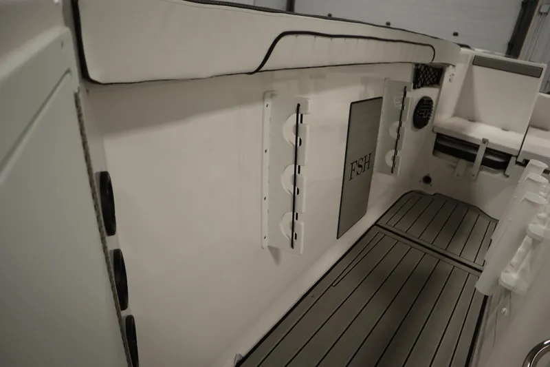 Slide: The Image of 2026 Yamaha Boats 222 FSH Sport E interior with cushioned seating and rod holders. - 26