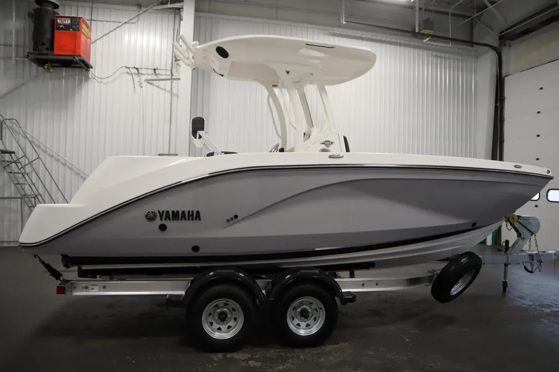 Slide: The Image of 2026 Yamaha Boats 222 FSH Sport E on trailer in indoor setting. - 3