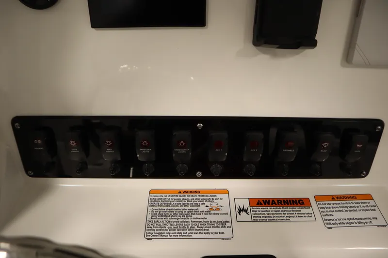 Slide: The Image of Control panel of 2026 Yamaha Boats 222 FSH Sport E with labeled switches and warning labels. - 33
