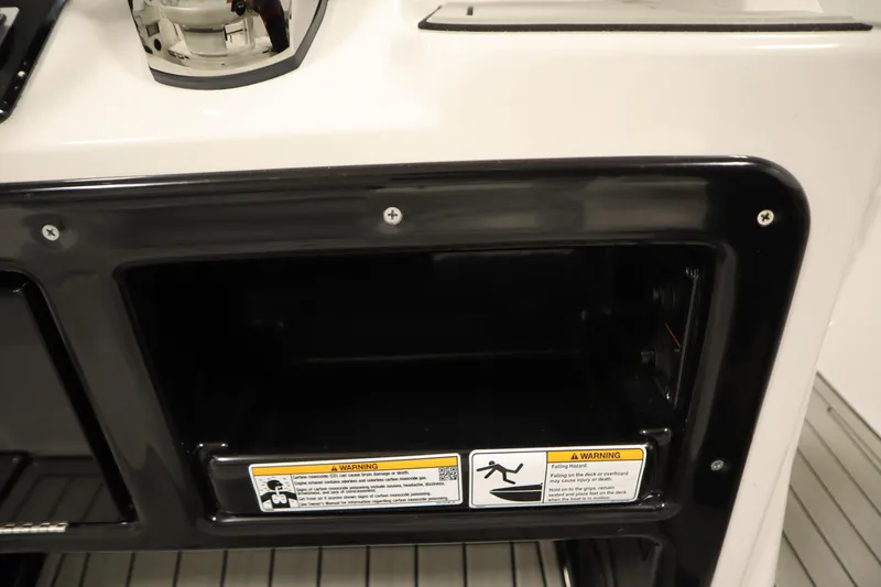Slide: The Image of 2026 Yamaha Boats 222 FSH Sport E storage compartment with safety warning labels. - 38
