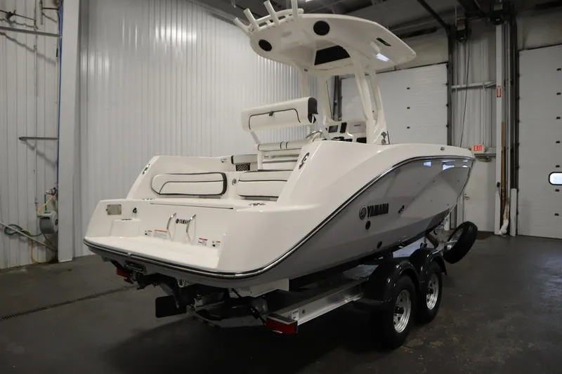 Slide: The Image of 2026 Yamaha Boats 222 FSH Sport E in a garage, rear view on trailer. - 4