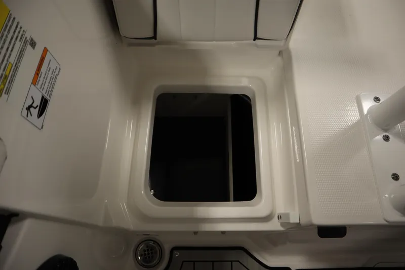 Slide: The Image of 2026 Yamaha Boats 222 FSH Sport E storage compartment, featuring sleek white interior design. - 45