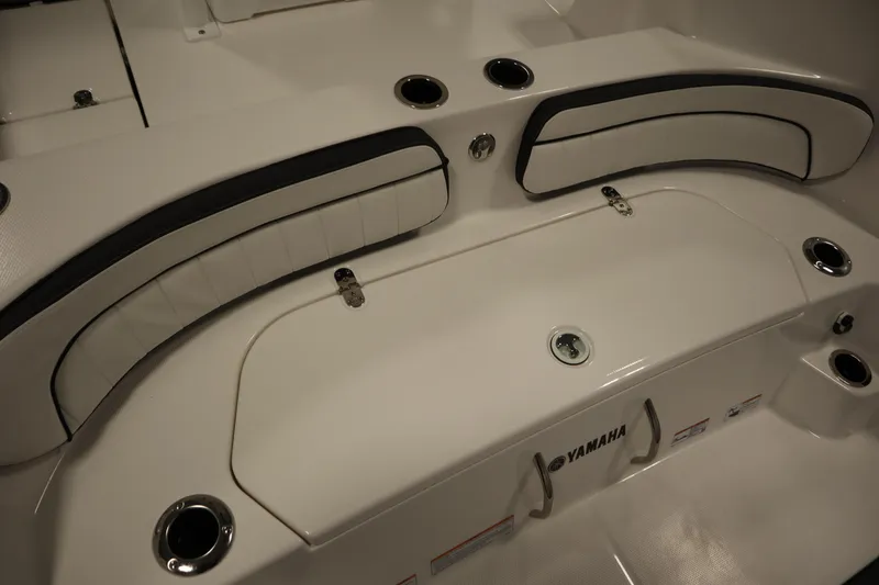 Slide: The Image of 2026 Yamaha Boats 222 FSH Sport E interior seating with cup holders and storage. - 47