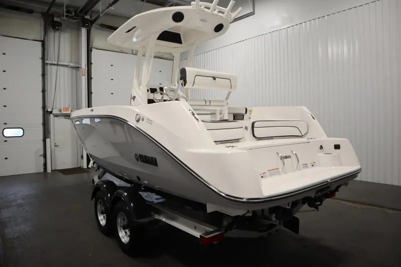 Slide: The Image of 2026 Yamaha Boats 222 FSH Sport E in a garage, rear view on trailer. - 6