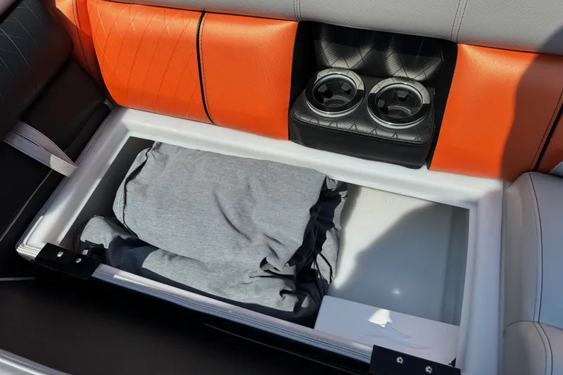 Slide: The Image of 2021 Berkshire 250 Super-Sport Premium boat seat storage with cup holders and folded clothing. - 36