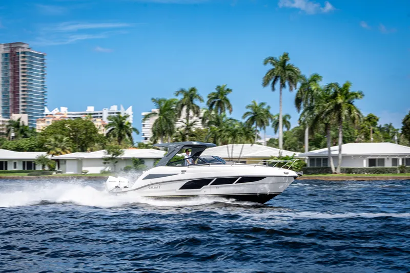 Slide: The Image of 2025 Valiatt 350GT yacht cruising on a sunny day with palm trees in the background. - 2