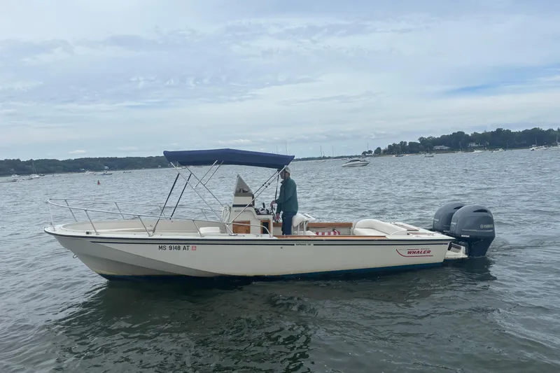 The Image of 1988 Boston Whaler 25 Outrage boat on water with canopy and twin Yamaha engines. - 1