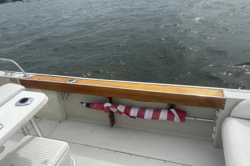 Slide: The Image of 1988 Boston Whaler 25 Outrage boat interior with wooden rail and folded flag. - 12