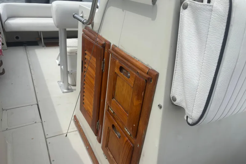 Slide: The Image of 1988 Boston Whaler 25 Outrage interior with wooden cabinets and white seating. - 13