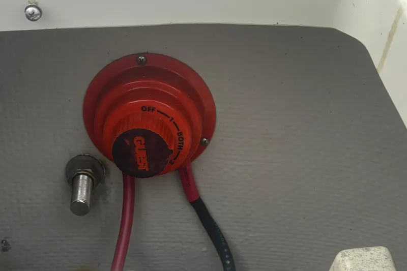 Slide: The Image of Battery switch on a 1988 Boston Whaler 25 Outrage boat, featuring red and black cables. - 14