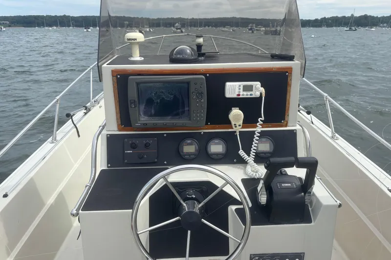Slide: The Image of 1988 Boston Whaler 25 Outrage boat dashboard with steering wheel and navigation equipment. - 9