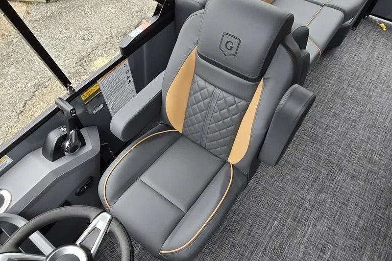 Slide: The Image of 2026 Godfrey SWEETWATER 2286 SB boat interior with luxurious captain's chair and steering wheel. - 6