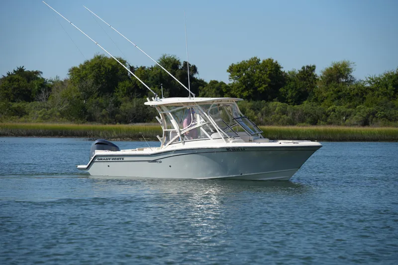 Slide: The Image of 2019 Grady-White Freedom 235 boat cruising on a calm lake with lush greenery. - 11