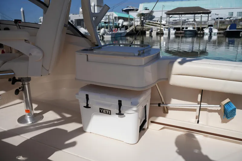 Slide: The Image of 2019 Grady-White Freedom 235 boat interior with Yeti cooler and marina view. - 16