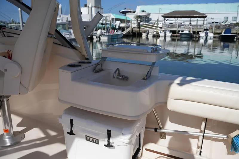 Slide: The Image of 2019 Grady-White Freedom 235 boat interior with seating and Yeti cooler at marina. - 17