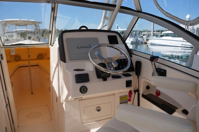 Slide: The Image of 2019 Grady-White Freedom 235 boat interior with Garmin navigation system and steering wheel. - 21