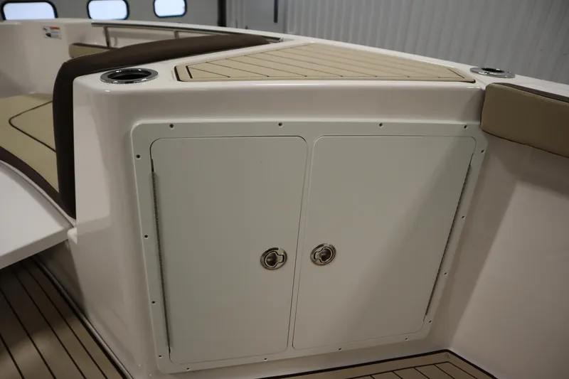 Slide: The Image of 2026 Yamaha Boats 252 FSH Sport interior storage compartment with sleek design and cup holders. - 16