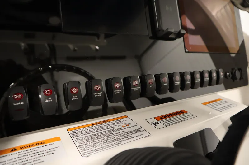 Slide: The Image of Control panel of 2026 Yamaha Boats 252 FSH Sport with labeled switches and warning labels. - 26
