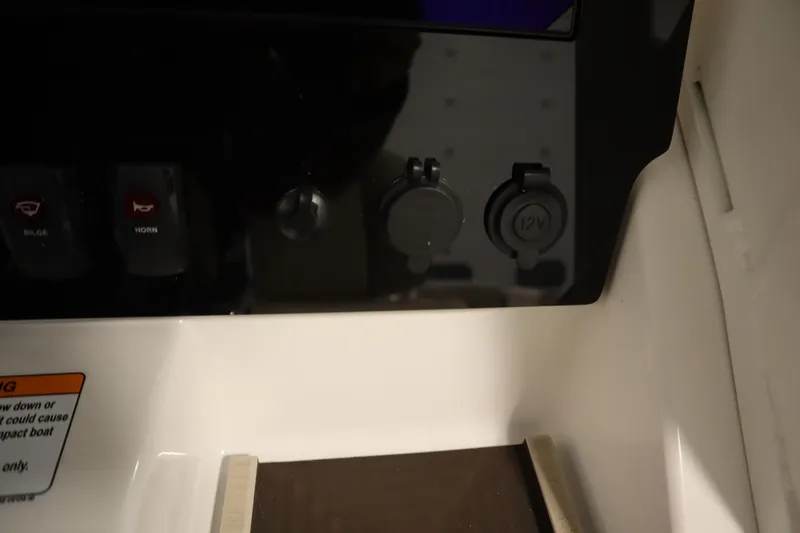 Slide: The Image of Control panel of 2026 Yamaha Boats 252 FSH Sport with switches and 12V outlet. - 27