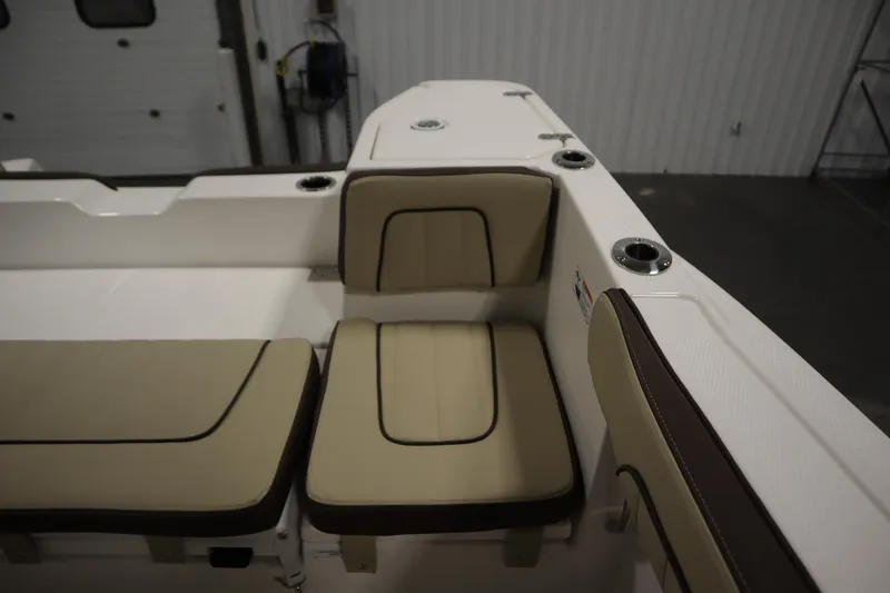 Slide: The Image of 2026 Yamaha Boats 252 FSH Sport interior seating with beige cushions and cup holders. - 32