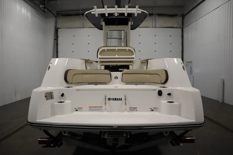 Slide: The Image of 2026 Yamaha Boats 252 FSH Sport, rear view in a spacious indoor setting. - 5