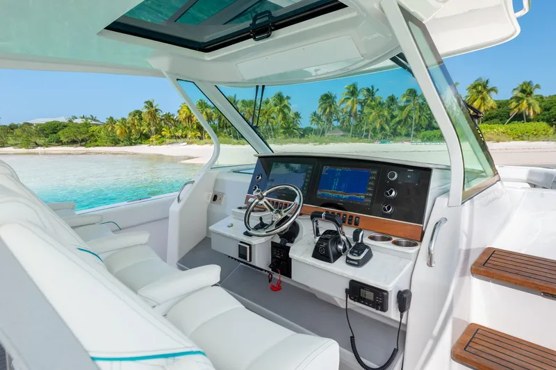 Slide: The Image of 2026 Regal 38 SAV boat interior with advanced navigation system, anchored near tropical beach. - 13