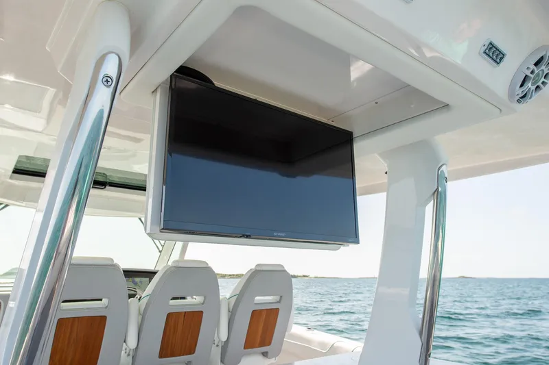 Slide: The Image of 2026 Regal 38 SAV boat interior with mounted TV and ocean view. - 14