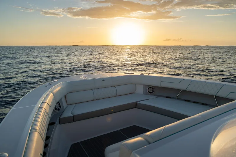 Slide: The Image of 2026 Regal 38 SAV boat at sunset, ocean view from deck seating area. - 23
