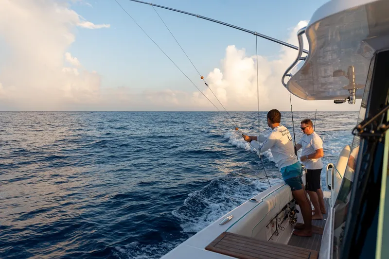 Slide: The Image of Two people fishing on a 2026 Regal 38 SAV boat at sea. - 31