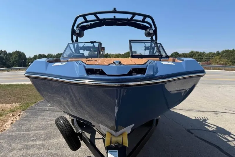 Slide: The Image of 2026 Yamaha Boats 222XE in blue, parked on a trailer, under clear skies. - 2