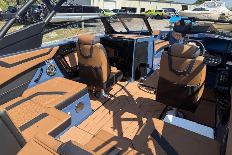 Slide: The Image of 2026 Yamaha Boats 222XE interior with brown and black seating, modern dashboard, and spacious layout. - 7