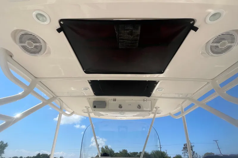 Slide: The Image of 2016 Pursuit S 280 Sport boat roof with speakers and hatch, under clear blue sky. - 10