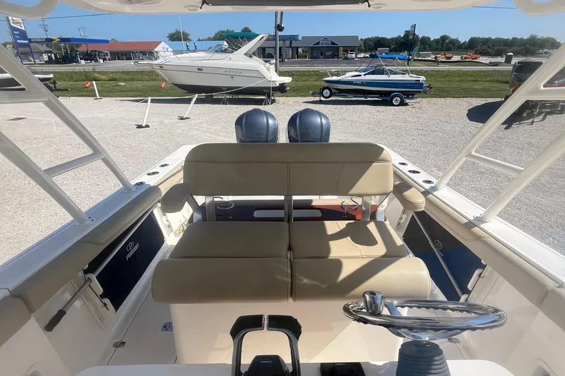 Slide: The Image of 2016 Pursuit S 280 Sport boat interior with dual engines, beige seating, and steering wheel. - 13
