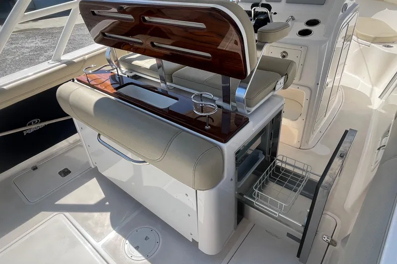 Slide: The Image of 2016 Pursuit S 280 Sport boat interior with seating and storage features. - 17